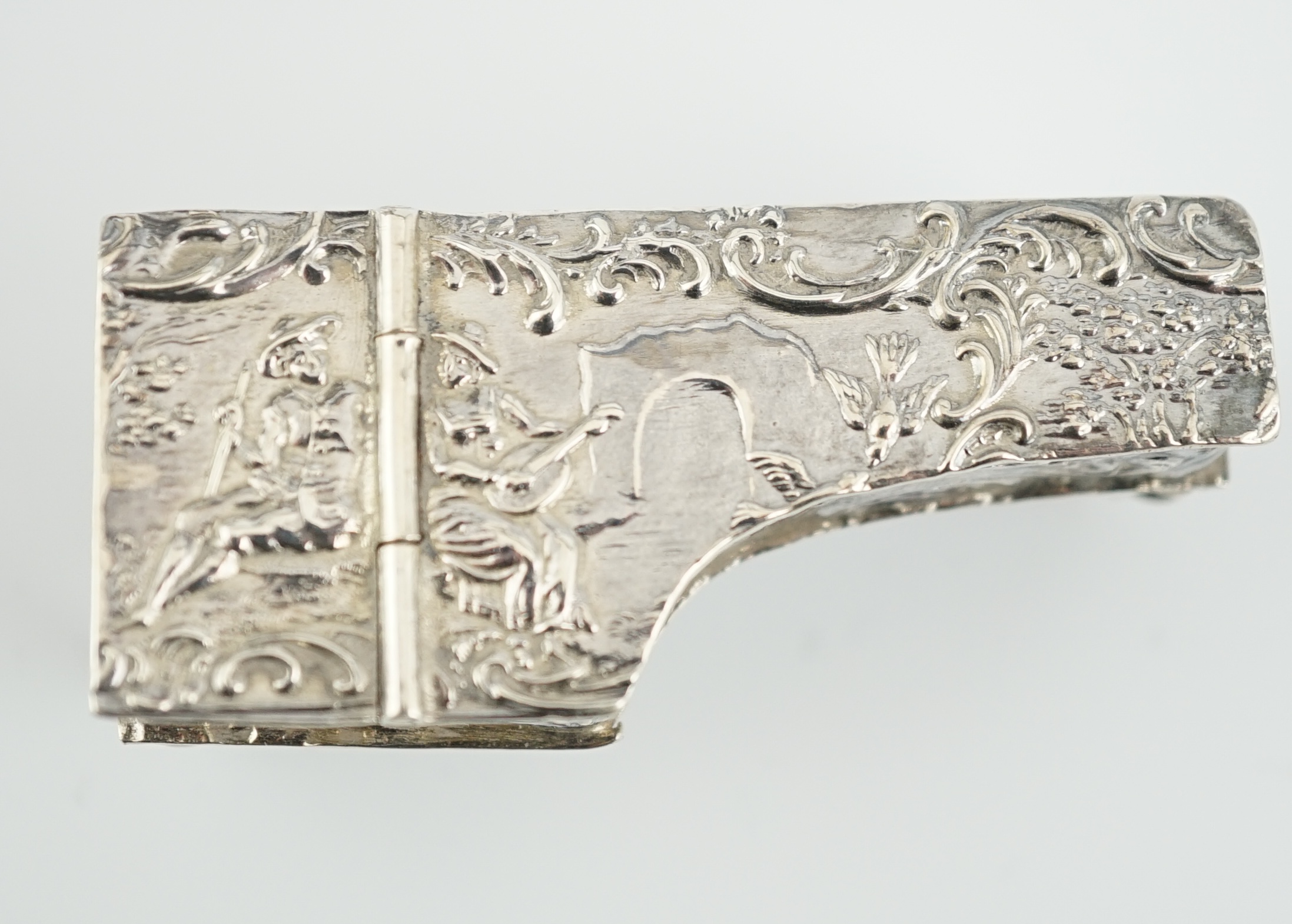 A late 19th century continental embossed silver miniature model of grand piano, length 53mm, together with a similar model of a table/desk on ornate scroll supports